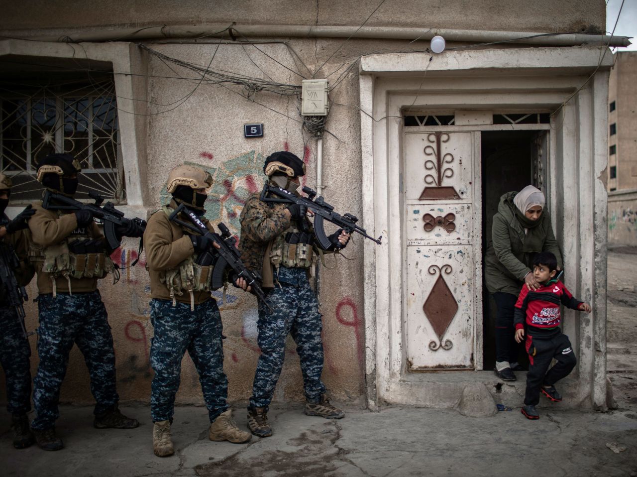 A woman and her children leave their home in Hasakah, Syria, as Kurdish special forces went house to house conducting searches for escaped prisoners on Thursday, January 27. It was days after several ISIS members <a href="https://www.cnn.com/2020/03/30/middleeast/isis-prison-escape-syria-intl-hnk/index.html" target="_blank">escaped from a nearby prison.</a>