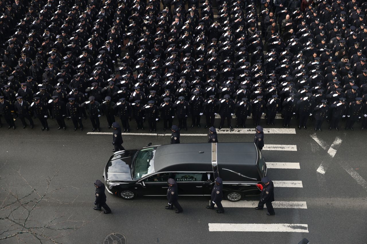 New York police officers salute a hearse carrying the casket of Officer Wilbert Mora after Mora's funeral on Wednesday, February 2. Mora and his partner, Jason Rivera, <a href="https://www.cnn.com/2022/01/26/us/nypd-officer-shooting-wednesday/index.html" target="_blank">were fatally shot last month.</a>