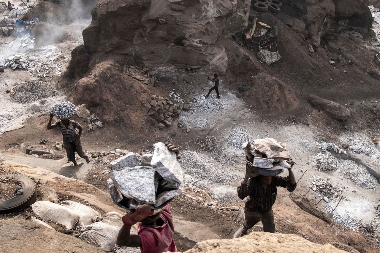 People carry out pans of granite from a granite mine in Ouagadougou, Burkina Faso, on Saturday, January 29. Hundreds of miners carry out small and large chunks up the crater's steep walls every day.