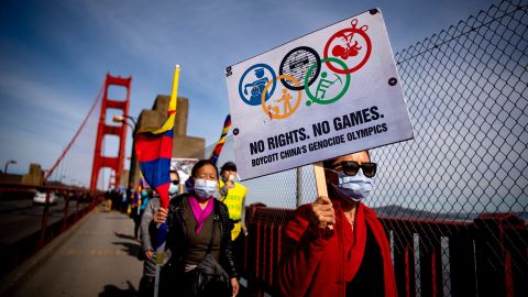 Protesters hold up signs while marching across the Golden Gate Bridge during a demonstration against the 2022 Beijing Winter Olympics in San Francisco, California on February 3.