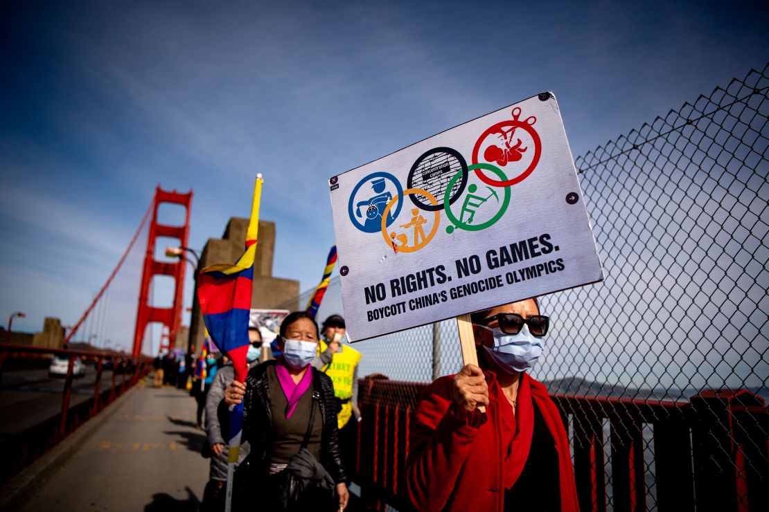 Protesters hold up signs while marching across the Golden Gate Bridge during a demonstration against the 2022 Beijing Winter Olympics in San Francisco, California on February 3.