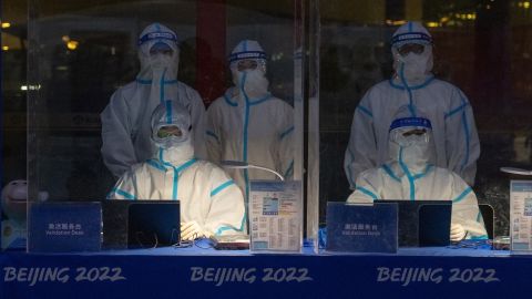 Officials decked in personal protective equipment wait to validate Olympic accreditation for people arriving at Beijing Capital International Airport on January 24.