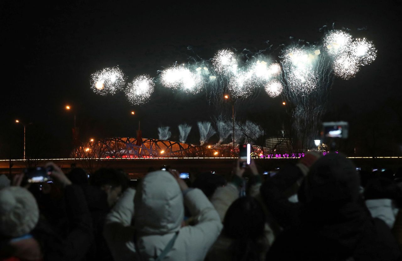 People watch the fireworks light up the sky over the Beijing National Stadium, which is nicknamed the Bird's Nest.