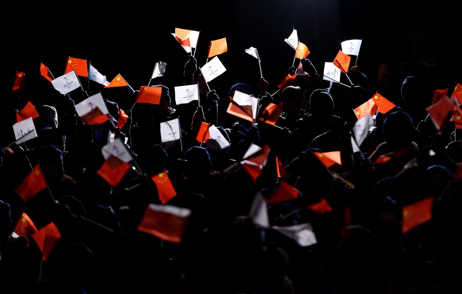 Members of the audience wave flags during the opening ceremony.