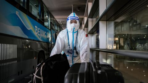 An Olympic worker wheels suitcases onto a media transportation bus at the Beijing airport on February 2, ahead of the Winter Olympics.