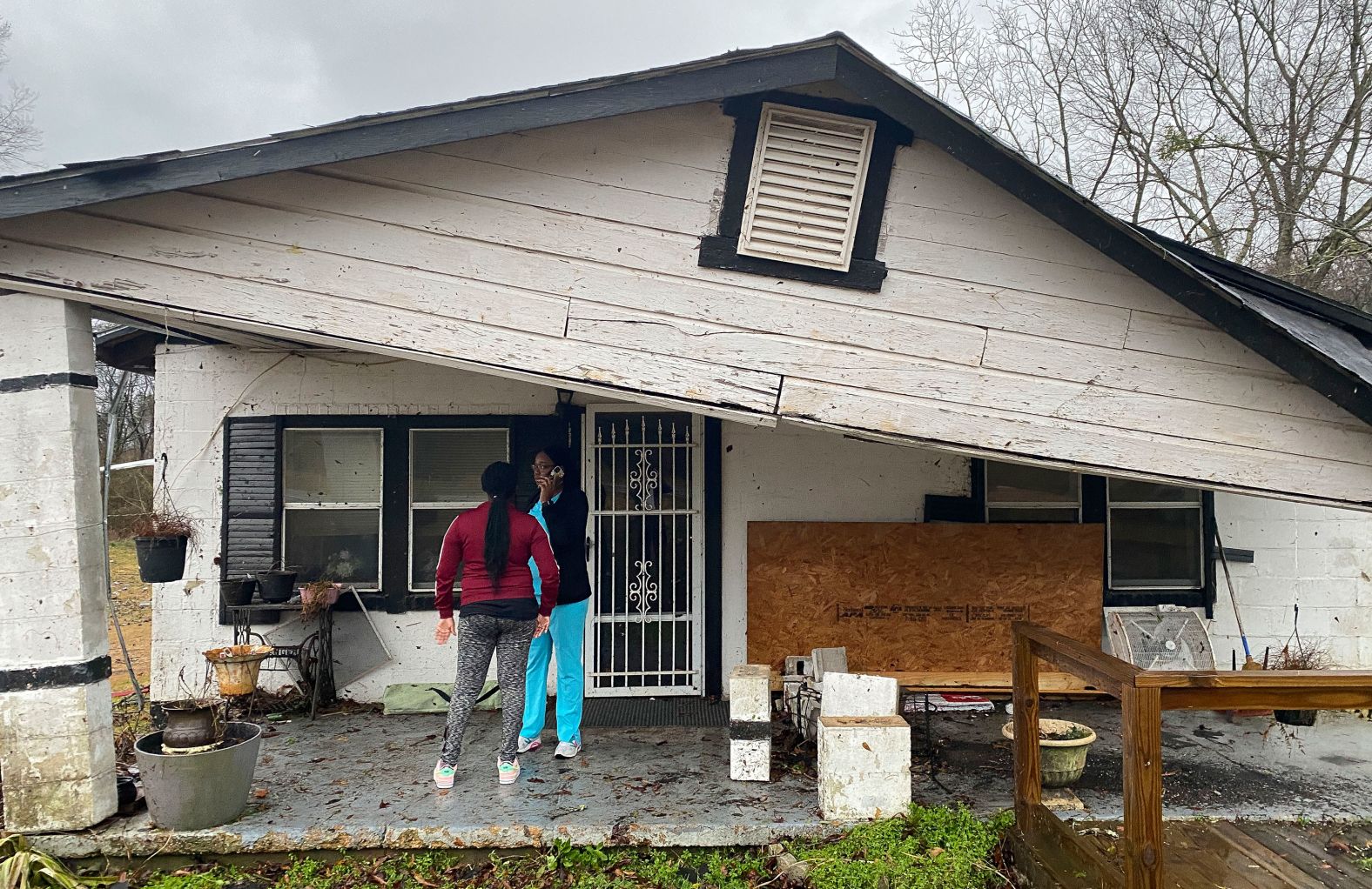Jacquayla Fields and her mother, Tiffany Thomas, stand beneath the damaged front porch of a house belonging to Thomas' uncle after a tornado struck Hale County, Alabama, on February 3. No one in the house was hurt.