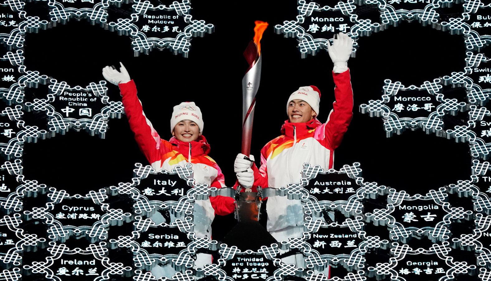 Chinese athletes Dinigeer Yilamujian, left, and Zhao Jiawen wave as they place the Olympic flame into a giant snowflake during the <a href="index.php?page=&url=http%3A%2F%2Fwww.cnn.com%2F2022%2F02%2F04%2Fsport%2Fgallery%2Fopening-ceremony-beijing-winter-olympics%2Findex.html" target="_blank">opening ceremony</a> on February 4. The choice of Dinigeer and Zhao <a href="index.php?page=&url=https%3A%2F%2Fedition.cnn.com%2Fworld%2Flive-news%2Fbeijing-winter-olympics-2022-opening-ceremony-spt-intl-hnk%2Fh_4474af75fecfed6a2f010181e818974c" target="_blank">appeared symbolic and deliberate.</a> Dinigeer is a Uyghur, an ethnic minority in China's far west region of Xinjiang where China has been accused of massive human-rights violations. Zhao is of Han decent, the dominant ethnicity in China.