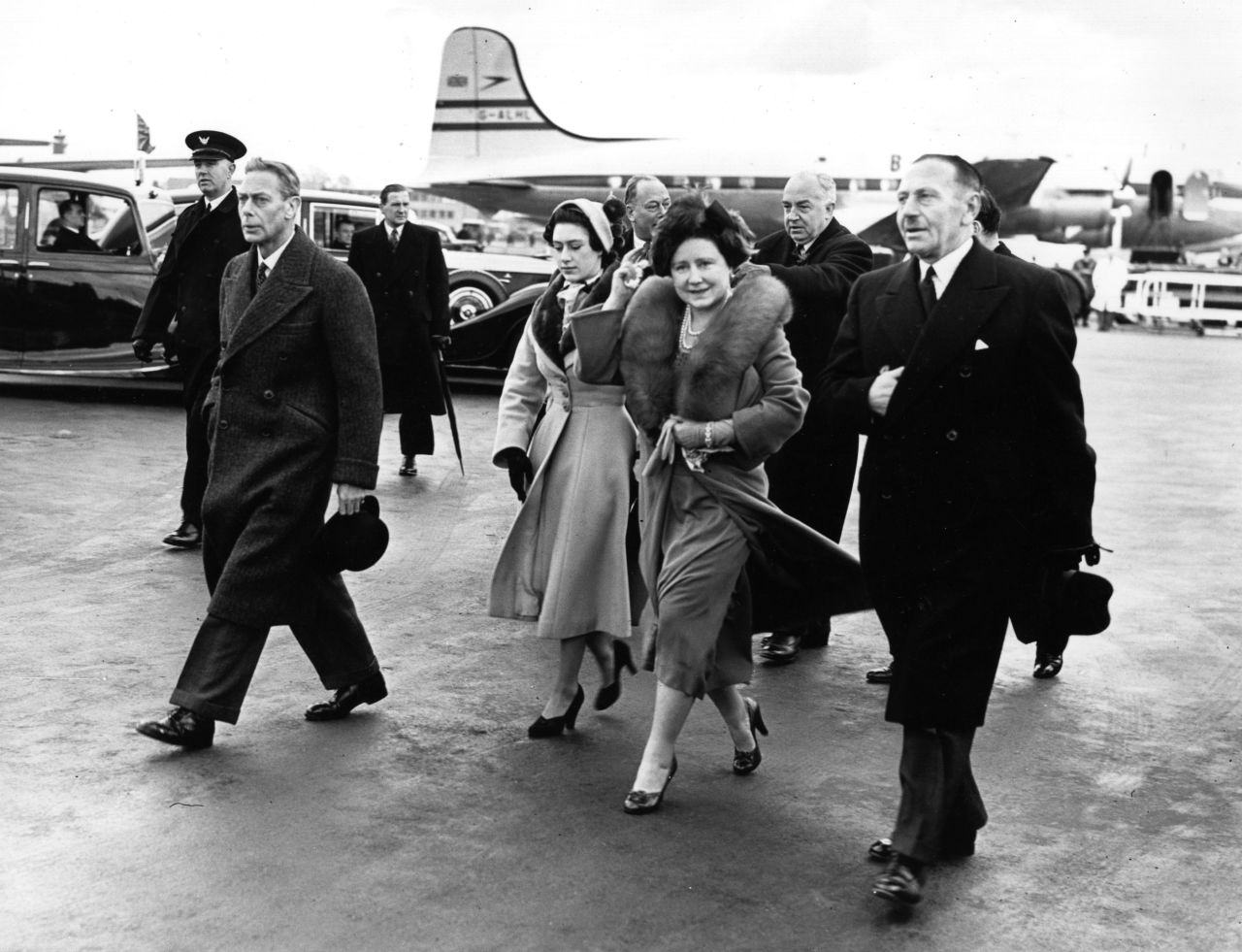 King George VI, left, is joined by his wife, Elizabeth, and Princess Margaret as he leaves an airport in London on January 31, 1952. They had waved farewell to Princess Elizabeth and her husband, Prince Philip, who were heading on a royal tour.