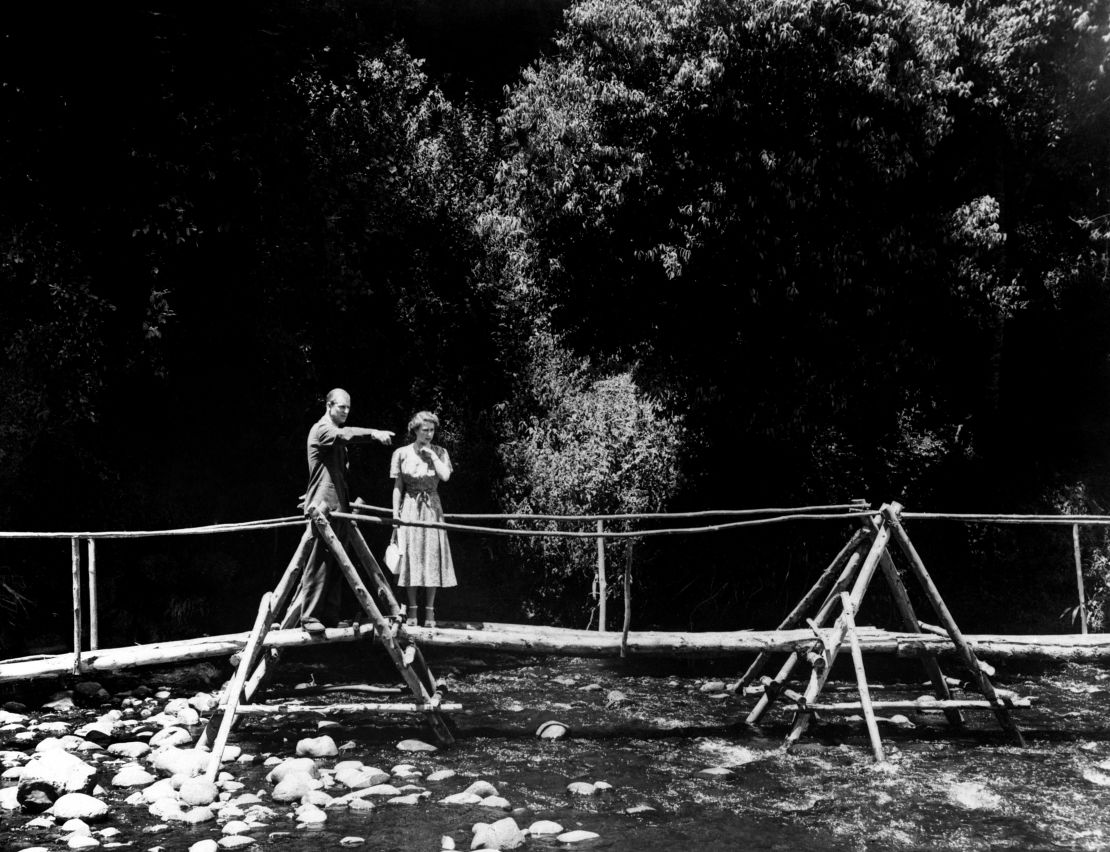 Princess Elizabeth and the Duke of Edinburgh pause on the rustic bridge in the grounds of the Royal Lodge, Sagana, their wedding present from the people of Kenya.