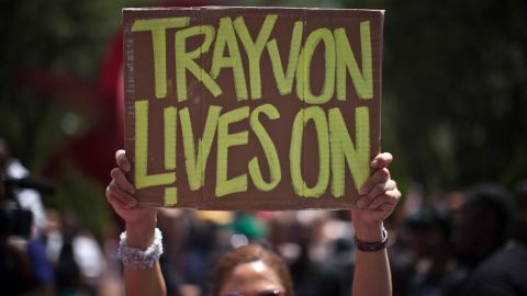 A woman holds a sign as she attends a rally honoring Trayvon Martin organized by the National Action Network outside One Police Plaza in Manhattan on July 20, 2013 in New York City.