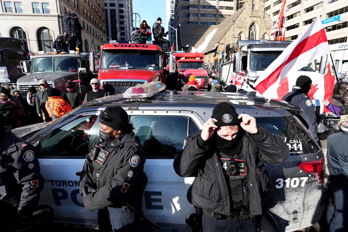 Trucks attempting to drive down University Avenue in Toronto are blocked by a police cruiser on Saturday, February 5, during a demonstration in support of a trucker convoy.