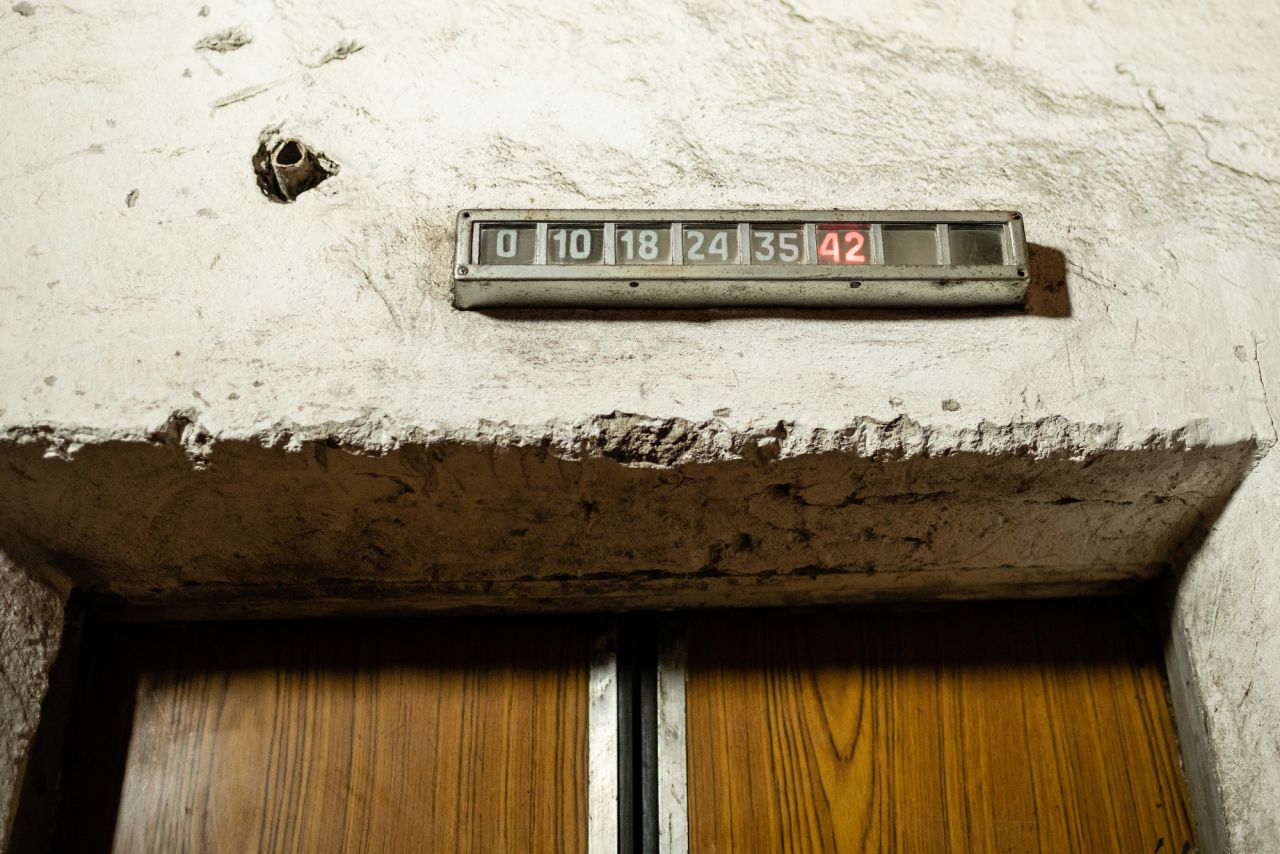 An elevator's indicator shows the height to upper floors in meters.