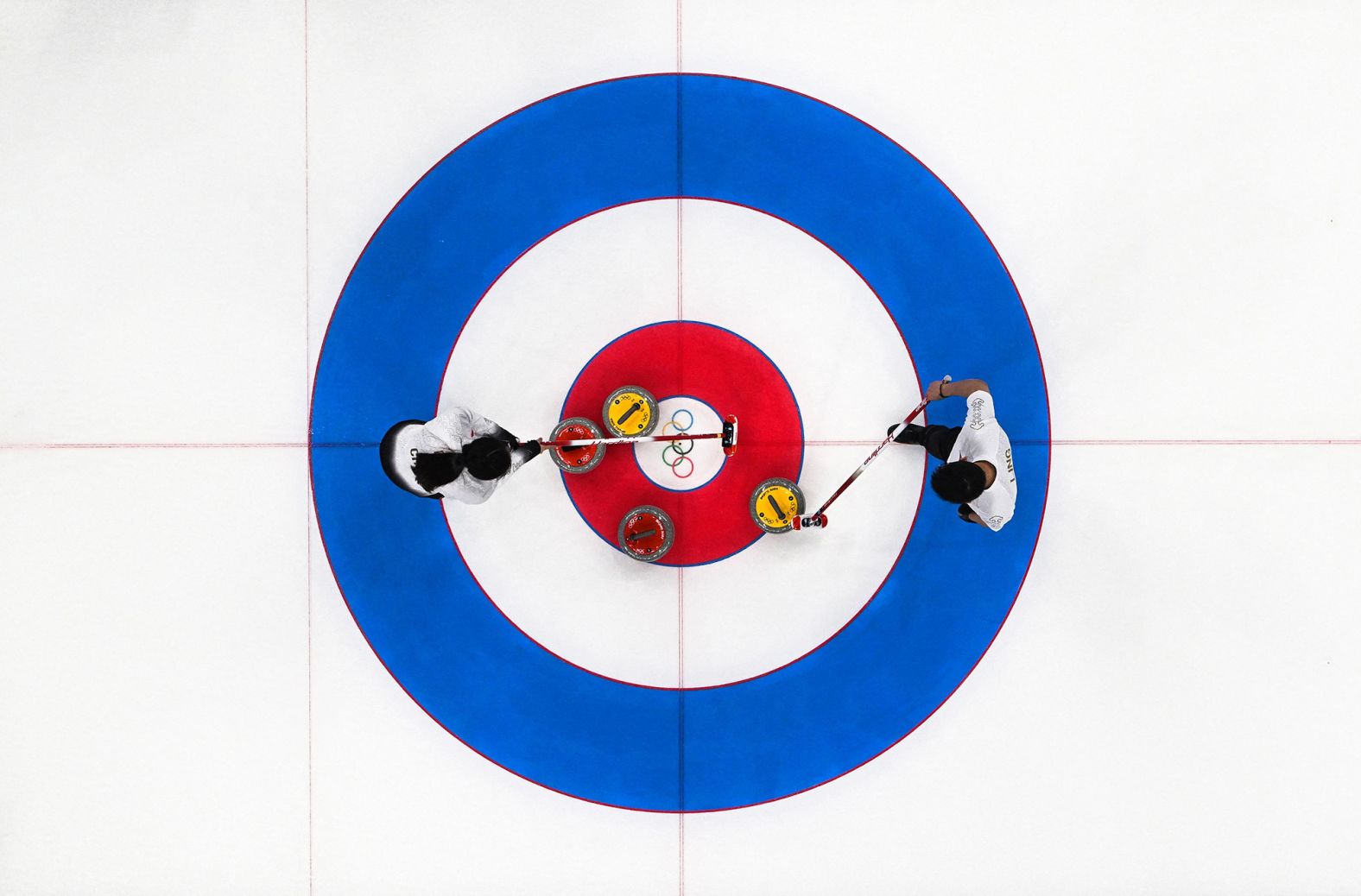 Chinese curlers Fan Suyuan, left, and Ling Zhi strategize while competing in a mixed-doubles match against Great Britain on February 6.