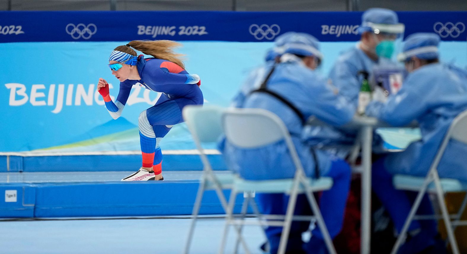 Russian speedskater Elena Sokhryakova skates past medical personnel as she warms up for the 1,500 meters on February 7.