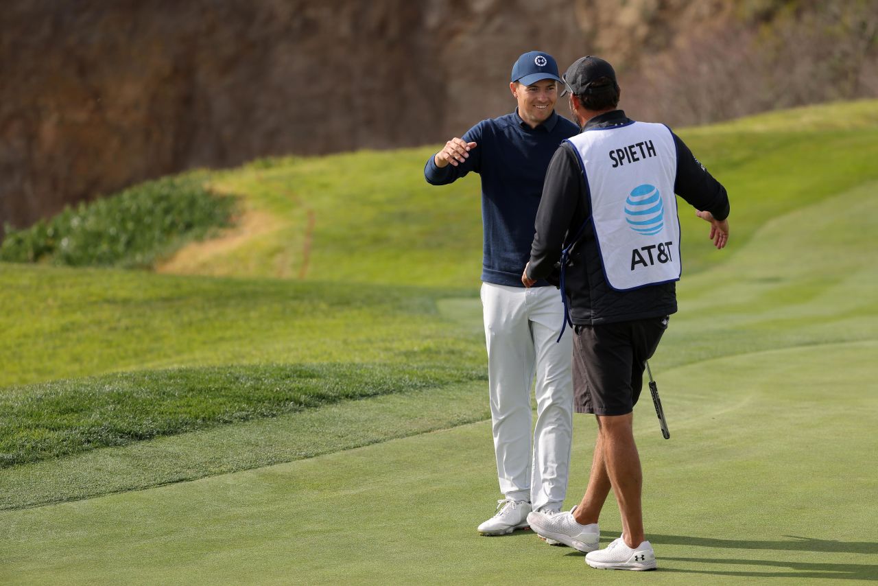 Spieth and caddie Michael Greller hug after the US golfer made his putt on the eighth green to salvage a par.