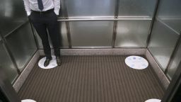 An employee stands on a social distancing marker in an office elevator in Dallas, Texas, in September 2020.