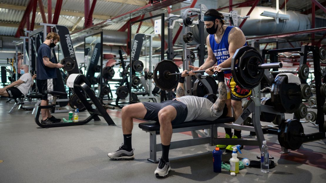 People wearng masks work out at a gym in Manhattan, New York City, on May 19, 2021. 