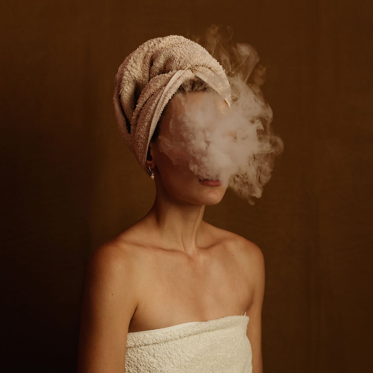 Greek photographer Foteini Zaglara's self portrait, "Rolling Boil," shows her as she blows a plume of smoke into the camera.