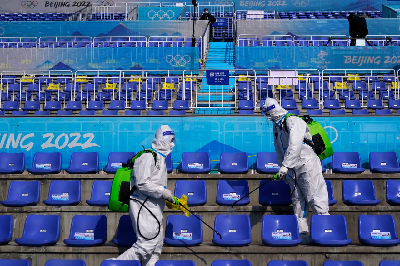 Workers in protective gear disinfect seats after the big air competition on February 9.