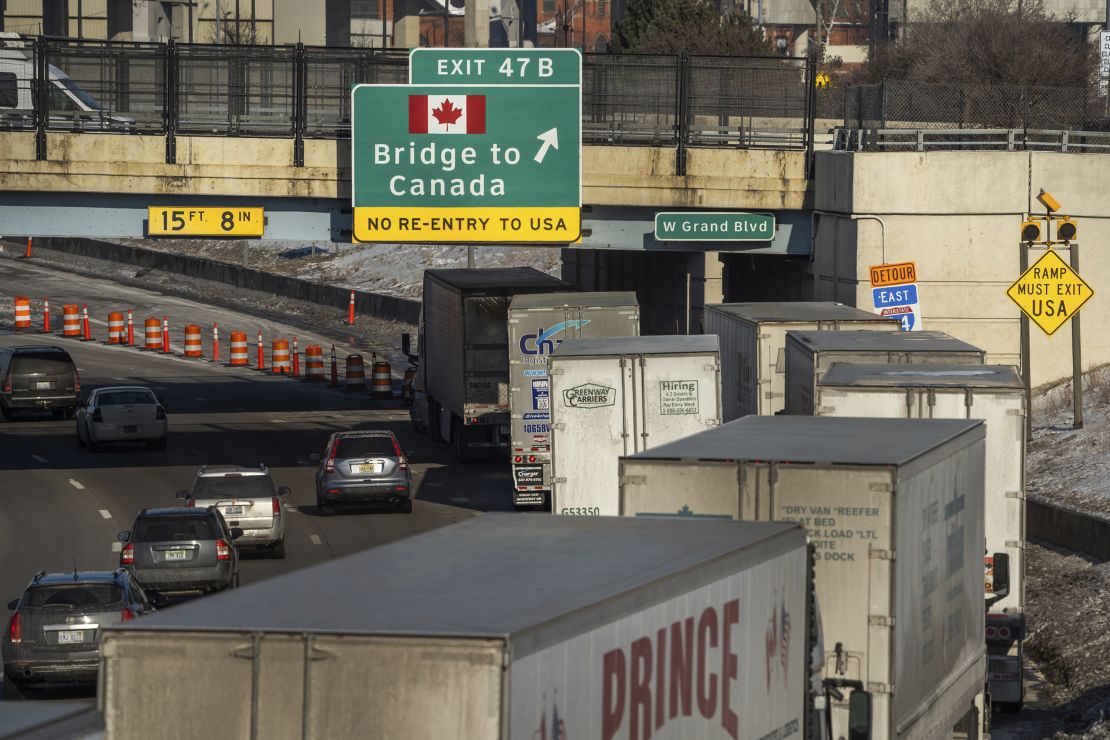 A small line of semi-trailer trucks line up along northbound I-75 in Detroit as the Ambassador Bridge entrance is blocked off for travel to Canada on February 8.