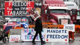 A protester walks in front of parked trucks as demonstrators continue to protest the vaccine mandates implemented by Prime Minister Justin Trudeau on February 8, 2022 in Ottawa, Canada. (Photo by Dave Chan / AFP) (Photo by DAVE CHAN/AFP via Getty Images)