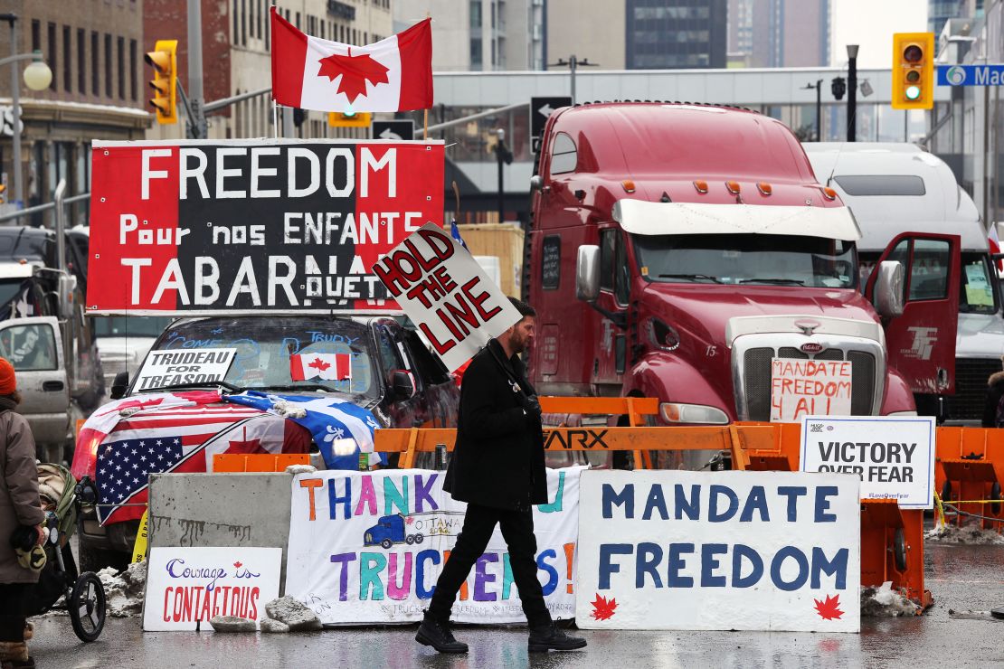 A protester walks in front of parked trucks in Ottawa as demonstrations continue over vaccine mandates and coronavirus restrictions on February 8.