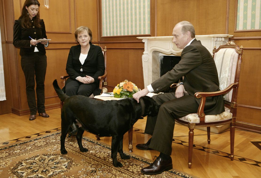 Russian President Vladimir Putin pets his dog during a press conference with German Chancellor Angela Merkel in Sochi, 2007. 