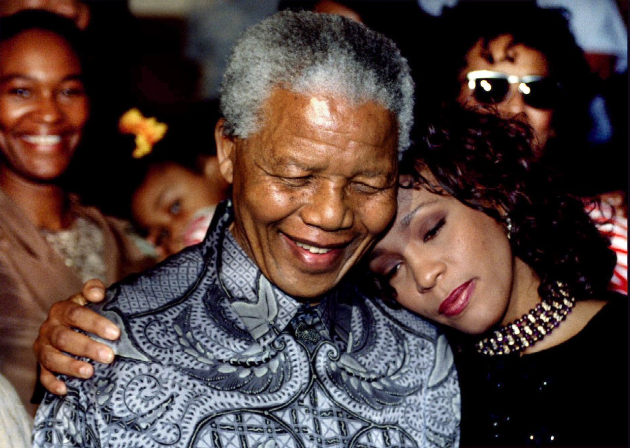 South African President Nelson Mandela and Whitney Houston smile for photographers at the presidency on November 10, 1994.