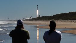 People watch from Canaveral National Seashore on February 9 as a SpaceX rocket launches from pad 39A at the Kennedy Space Center in Cape Canaveral, Florida, carrying 49 Starlink internet satellites.