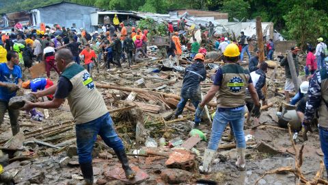 Neighbors join rescue workers in the hunt for survivors after a rain-weakened hillside collapsed over homes in Pereira, Colombia, on Tuesday.