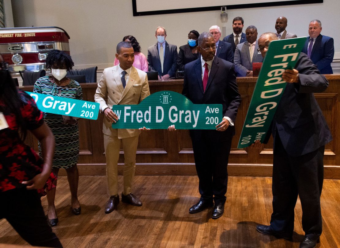 Montgomery Mayor Steven Reed, second from left, poses with Fred Gray Jr. and Stanley Gray after the city council voted unanimously to rename Jefferson Davis Avenue after Gray's father, civil rights attorney Fred Gray last year.