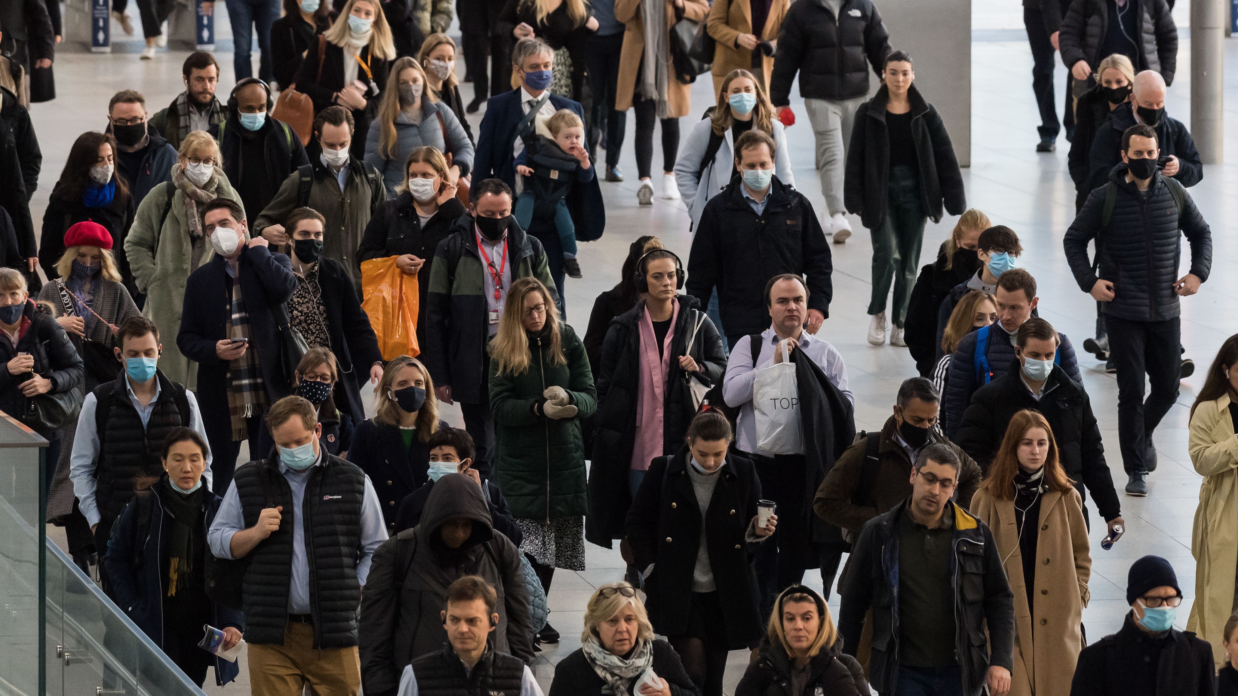 Commuters, some continuing to wear face masks, arrive at Waterloo Station during morning rush-hour on February 2, 2022 in London, England.