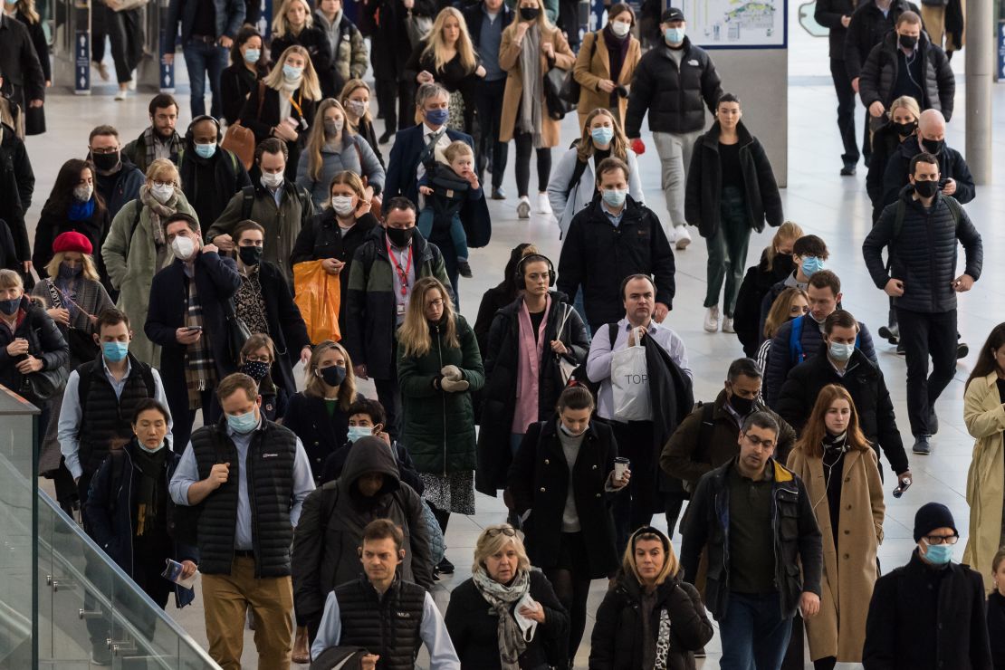 Commuters, some continuing to wear face masks, arrive at Waterloo Station during morning rush-hour on February 2, 2022 in London, England.