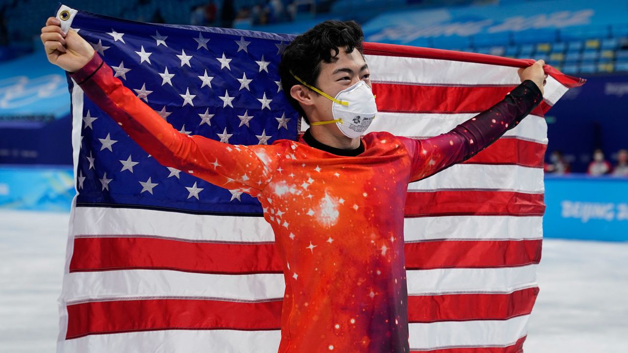 Nathan Chen, of the United States, holds his national flag as he celebrates after winning the gold medal in the men's free skate program during the figure skating event at the 2022 Winter Olympics, Thursday, Feb. 10, 2022, in Beijing. (AP Photo/David J. Phillip)