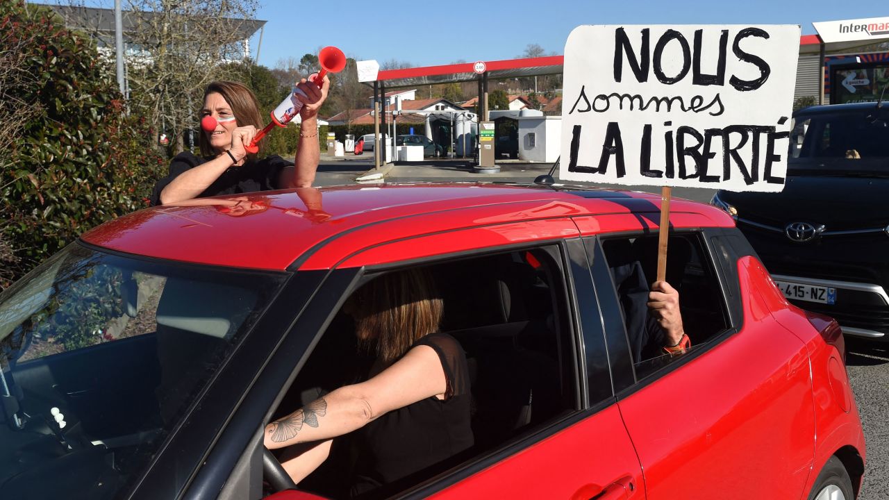 A placard that reads, "We are liberty" is held out of a car window as one convoy leaves Bayonne on February 9.