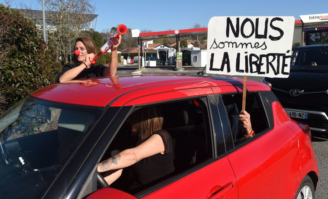 A placard that reads, "We are liberty" is held out of a car window as one convoy leaves Bayonne on February 9.