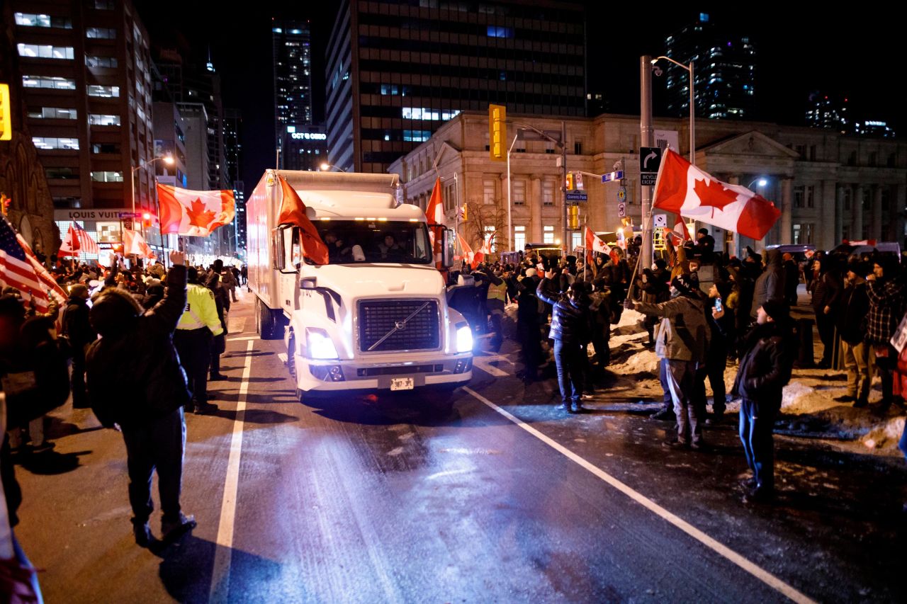 Supporters wave flags as a convoy of trucks moves through Toronto on February 5.