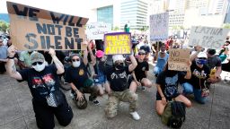 Protesters take a knee to demonstrate in front of Dallas City Hall in downtown Dallas, Saturday, May 30, 2020. Protests across the country have escalated over the death of George Floyd who died after being restrained by Minneapolis police officers on Memorial Day. (AP Photo/LM Otero)