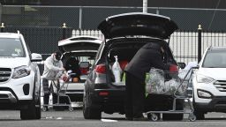 Two people load their cars with groceries in the parking lot of a Chinese supermarket in the Elmhurst neighborhood of the Queens borough of New York City on January 13.