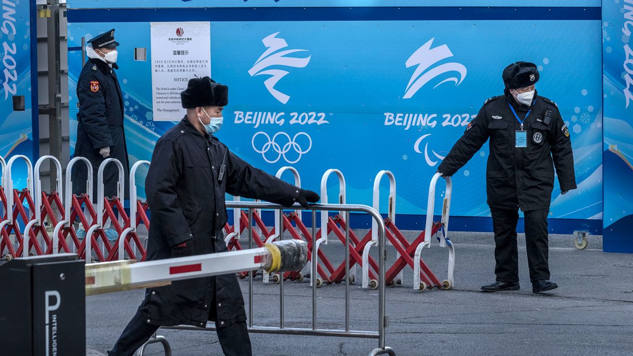 Guards secure barriers after a bus arrives at a hotel that is part of the Olympics closed loop bubble.