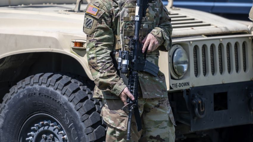 A member of the Texas National Guard holds a gun during a news conference with Greg Abbott, governor of Texas, not pictured, in Mission, Texas, U.S., on Wednesday, Oct. 6, 2021. Abbott and Republican state chief executives from around the nation gathered at the border to again call attention to unauthorized immigration across the Rio Grande.