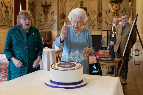 The Queen cuts a cake to celebrate the start of her <a href=