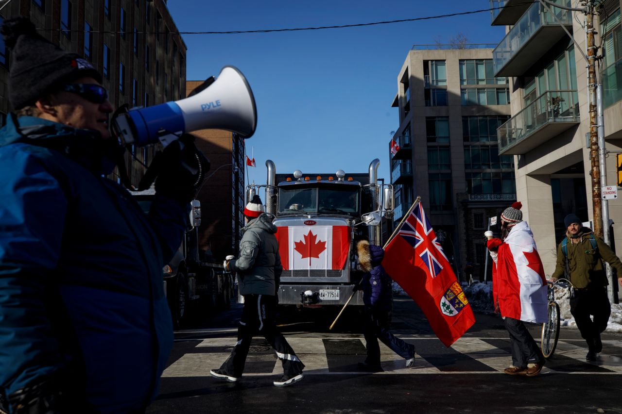 People pass by a honking truck in Toronto on Saturday, February 5, as they show their support for the truckers who have been protesting Covid-19 mandates in the Canadian capital of Ottawa. Thousands of truckers have been participating in the so-called <a href="https://www.cnn.com/2022/02/07/americas/canada-covid-protest-explainer/index.html" target="_blank">Freedom Convoy,</a> fighting a vaccine mandate that is forcing all Canadian truckers crossing the US-Canada border to be fully vaccinated or face quarantine in their homes for two weeks when they return. The protest has crippled downtown Ottawa, leading the mayor to declare a state of emergency.