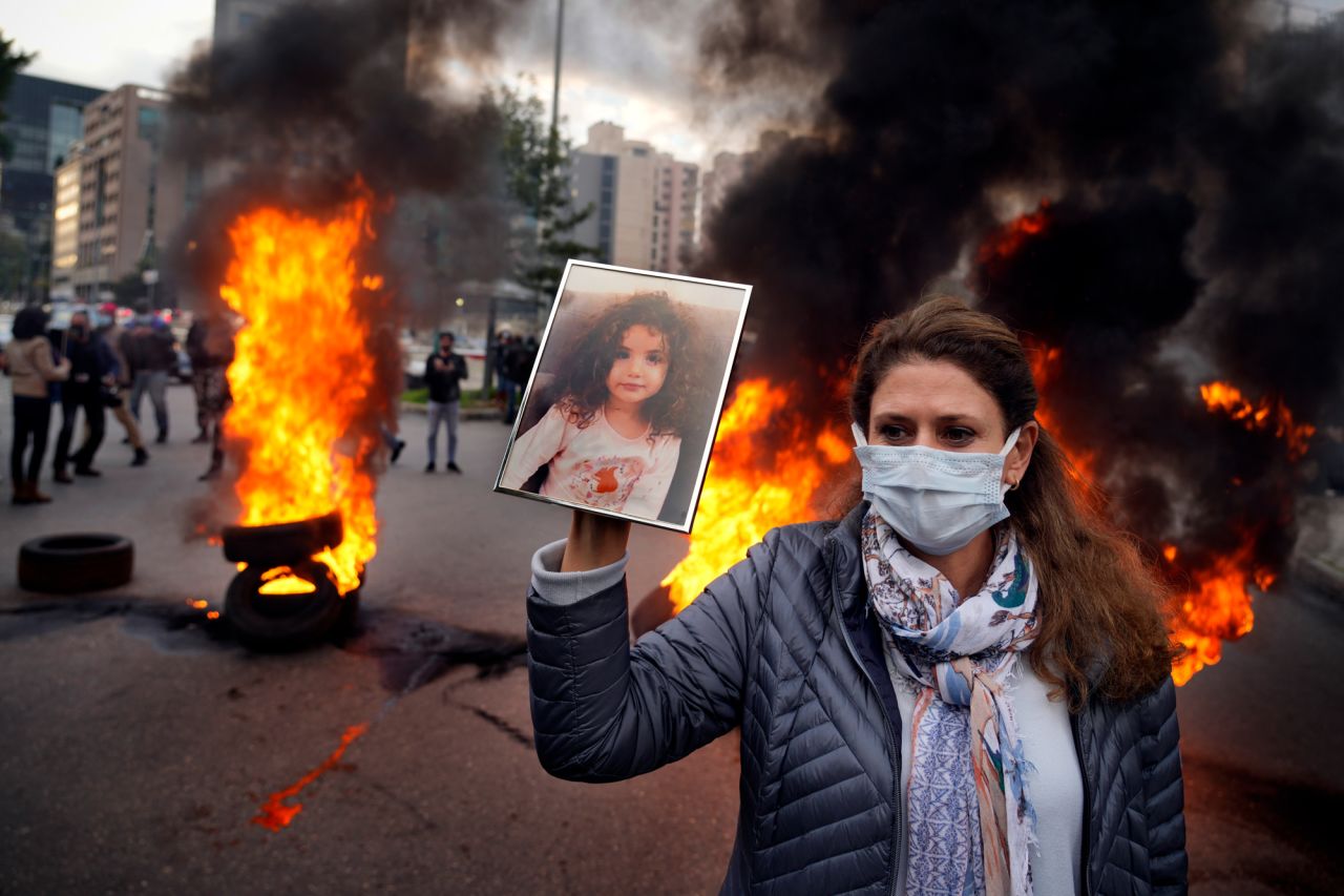 As a protest takes place in Beirut, Lebanon, on Monday, February 7, a woman holds a picture of her granddaughter who was killed in the city's <a href="http://www.cnn.com/2020/08/04/middleeast/gallery/beirut-explosion/index.html" target="_blank">port explosion in 2020.</a> The protest took place outside the Justice Palace and showed support for the judge who has been investigating the blast.