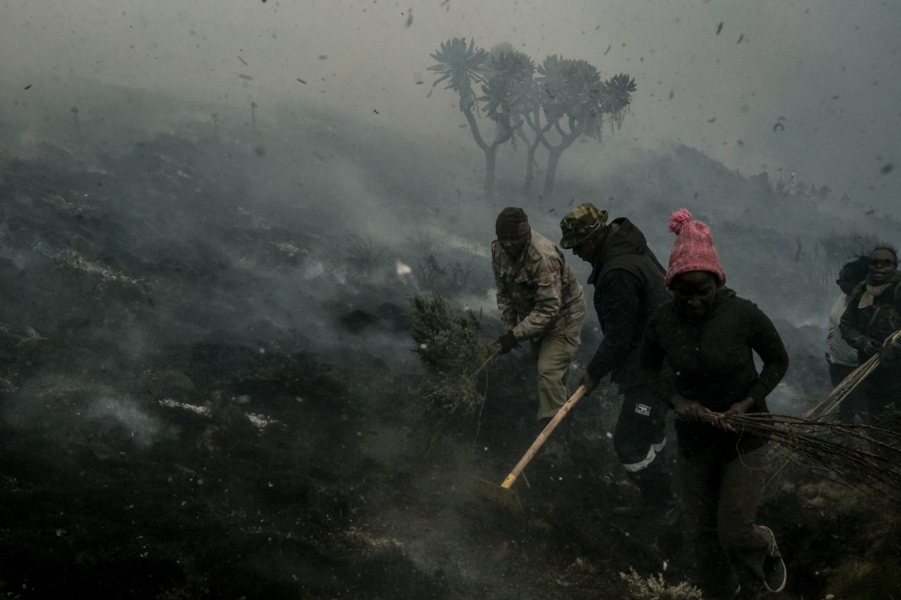 Members of the local scout community extinguish the edge of a burning area as they try stop the spread of a wildfire at the Aberdare National Park in Kenya on Monday, February 7.