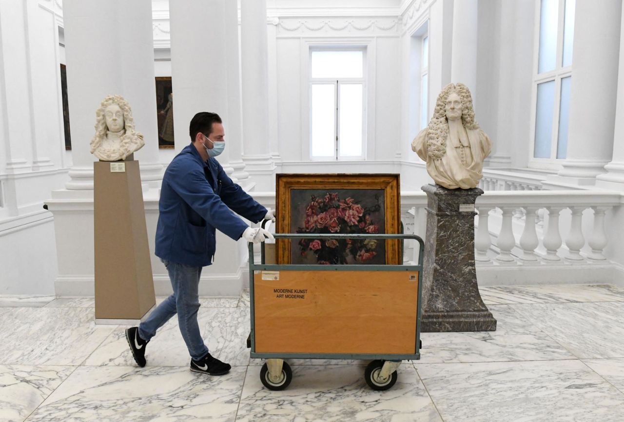 A staff member at the Royal Museums of Fine Arts wheels the painting away to be packed.