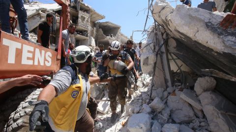 Members of the Syrian civil defence, known as the White Helmets, pull out a child from under the rubble following a reported Russian air strike on Maaret al-Numan in Syria's Idlib province in 2019. 
