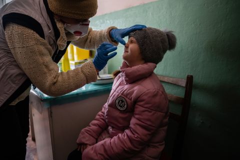 Nurse Lilia Schwez administers a Covid-19 test to 8-year-old Anhelina Yasinska in eastern Ukraine. Anhelina's mother was concerned about her daughter's fever, but she tested negative for Covid-19.