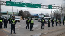 Police officers move in to clear traffic and protesters blocking access to the Ambassador Bridge during a demonstration in Windsor, Ontario, Canada, on Saturday, Feb. 12, 2022.