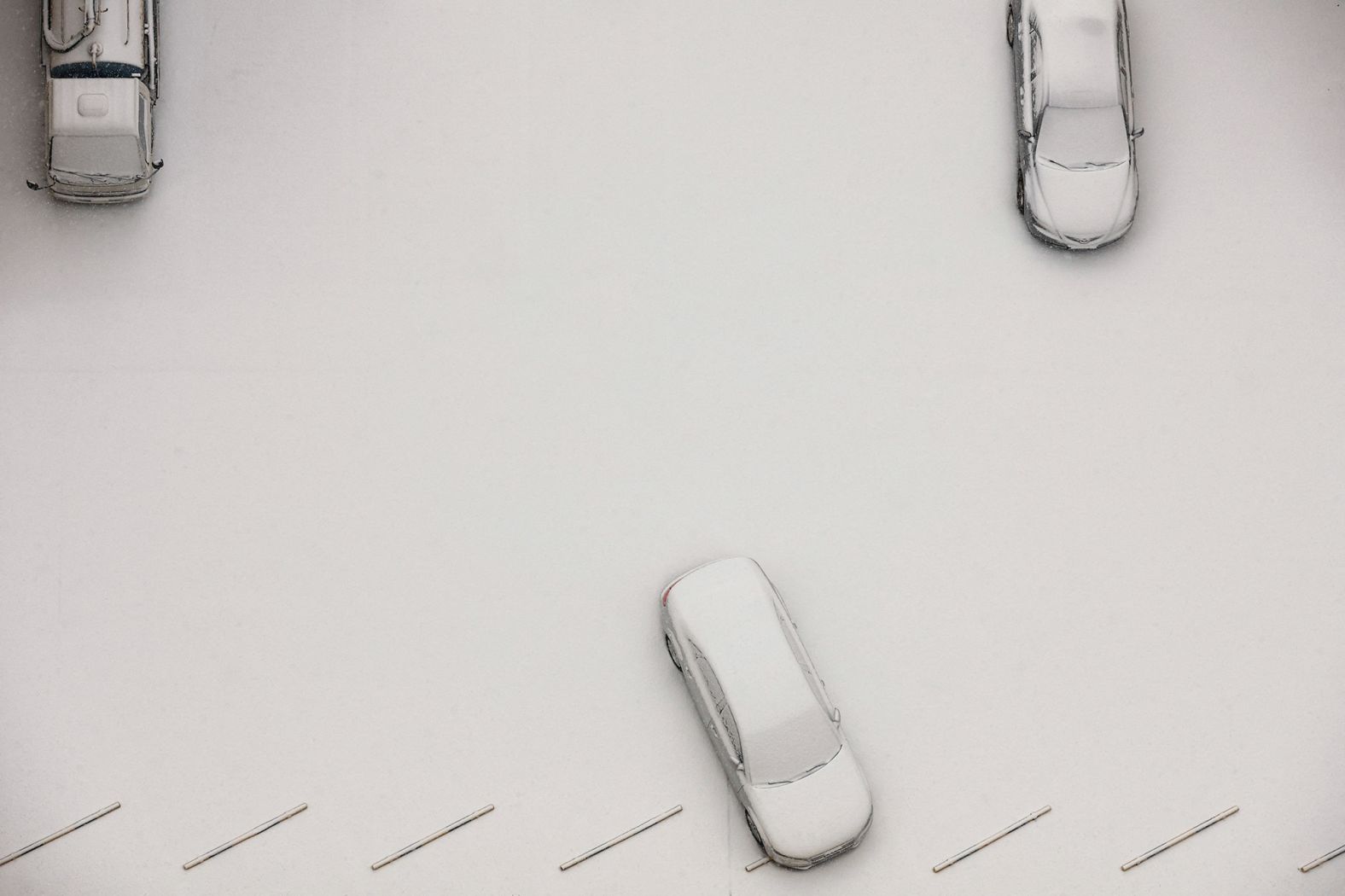 Snow-covered cars are seen from a hotel inside the "closed loop" that separates the Games from the rest of Beijing. It was the first time Beijing had seen snow since the start of the Games.